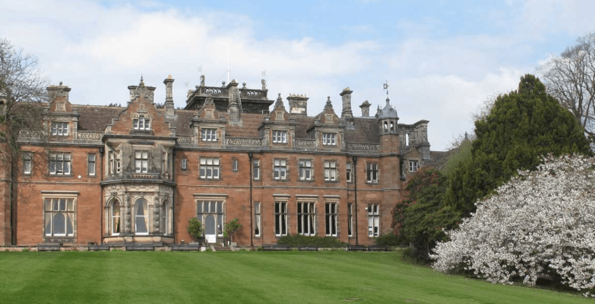 Photograph of Keele Hall which is a large building with green space in-front as well as trees to the right,